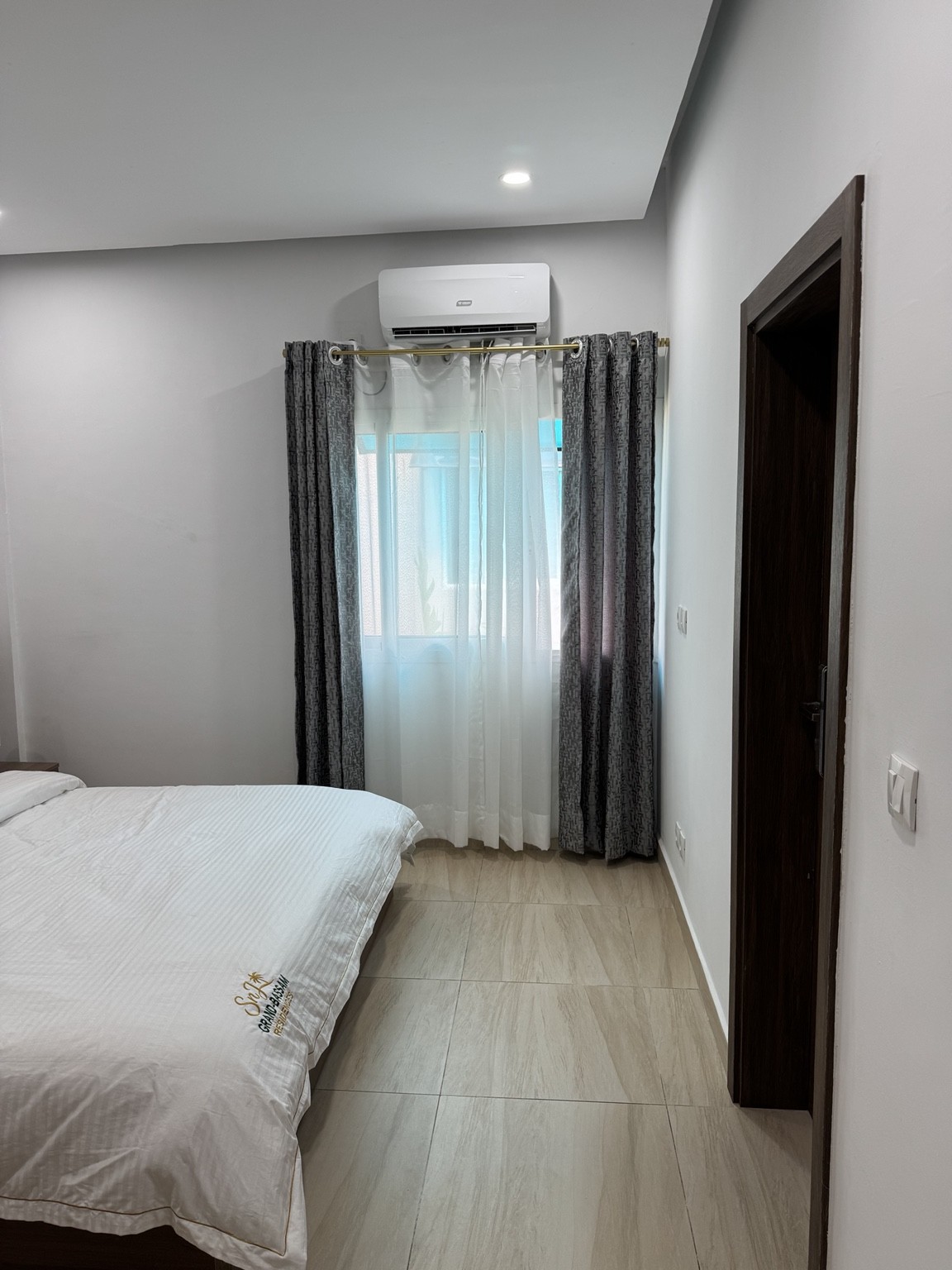 Chambre climatisée de la résidence avec lit double et rideaux